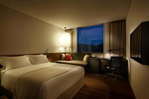 um quarto de hotel com uma cama, uma secretária e uma cadeira em Shilla Stay Dongtan em Hwaseong