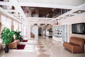 a lobby of a store with couches and plants at Hotel Rus in Tolyatti