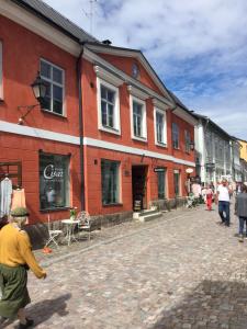 um grupo de pessoas andando por uma rua de paralelepípedos em Remuganes suite - Porvoon Linna em Porvoo
