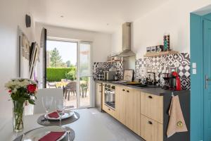 a kitchen with a table and a counter top at La Petite Californie in Saint-Illiers-la-Ville +4 photos