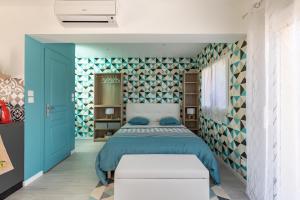 - une chambre avec un lit et un mur bleu dans l'établissement La Petite Californie, à Saint-Illiers-la-Ville