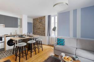 cocina y sala de estar con sofá y mesa en Le Dinanais - Cocon dans l'Intra Muros, en Saint-Malo