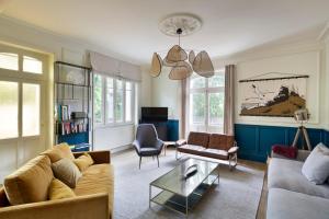 ein Wohnzimmer mit Sofa und Tisch in der Unterkunft Villa Marlotte by Cocoonr - La Belle de Dinard in Dinard