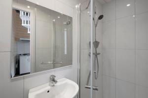 ein weißes Badezimmer mit Waschbecken und Dusche in der Unterkunft Villa Marlotte by Cocoonr - La Belle de Dinard in Dinard + 29 Fotos