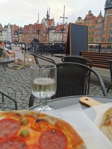 uma mesa com uma pizza e um copo de água em Mieszkanie przy morzu em Gdansk