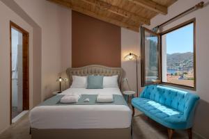 una camera da letto con un letto e un divano blu di Grace Hotel & Studios a Sými