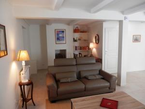a living room with a brown couch and a table at La Maison du vigneron in Ameugny