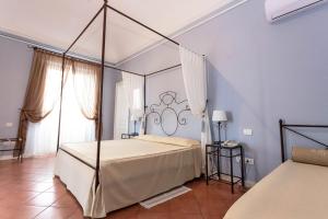 een slaapkamer met een hemelbed in een blauwe kamer bij Etna Hotel in Giarre