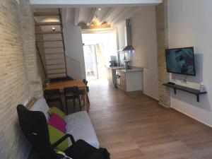 a living room with a couch and a tv on a wall at Casa La Placeta in Fortaleny