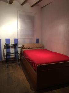 a bedroom with a red bed and a chair at Casa Valentina in Salvacañete