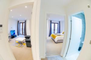 a bedroom with a bed and a room with a mirror at Beautiful 1 Bed Apartment in Centre of St Albans - Free Parking - 5 min walk to St Albans city centre & Railway station, 15mins drive to Harry Potter World - Free Super-fast Wifi in Saint Albans