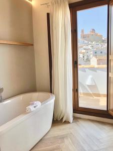 a bathroom with a bath tub and a large window at Hotel Abaco Altea in Altea
