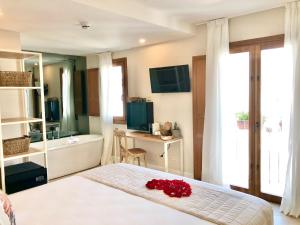 a bedroom with a bed and a bathroom with a tub at Hotel Abaco Altea in Altea