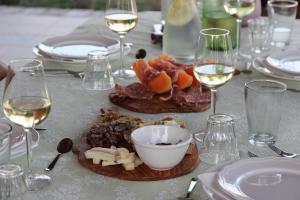 una tavola con piatti di cibo e bicchieri di vino di B & B La Primavera a Pergola