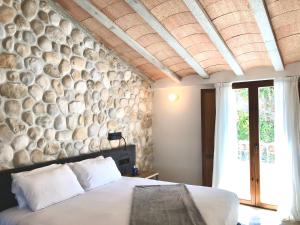 a bedroom with a stone wall and a bed at Hotel Abaco Altea in Altea