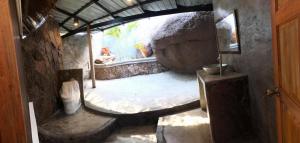 a room with a bed in a stone wall at Moondance Magic View Bungalow in Ko Tao