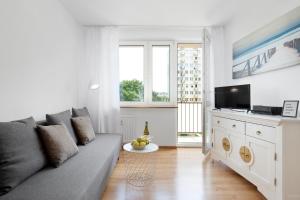 ein Wohnzimmer mit einem Sofa und einem TV in der Unterkunft Elite Apartments Gospody in Danzig