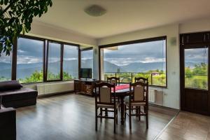 a dining room with a table and chairs and windows at Guest House Panorama in Gela