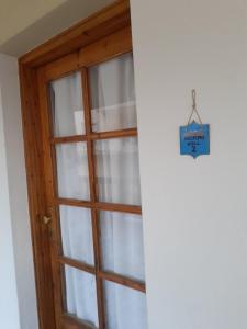 Una puerta con una ventana con un cartel. en OLYMPUS HILL, en Litóchoron