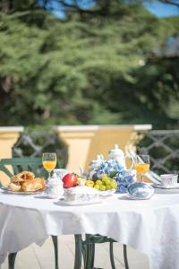 uma mesa branca com comida e taças de vinho em Hotel Boutique Edelweiss La Garriga em La Garriga