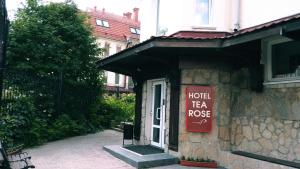 un signo de rosas de té del hotel en el lateral de un edificio en Tea Rose Hotel, en Yekaterinburg
