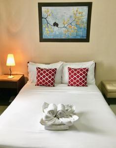 a bedroom with a white bed with red pillows at Residenciale Boutique Apartments in Manila