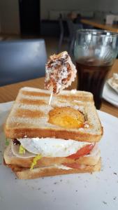 a sandwich with an egg on a plate on a table at Hostal Drago in Pueblo Nuevo de Guadiaro