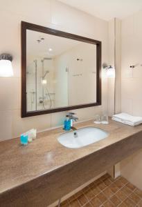 a bathroom with a sink and a large mirror at Hämeenkylän Kartano in Vantaa