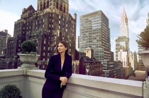a woman in a suit leaning against a wall in a city at InterContinental New York Barclay Hotel, an IHG Hotel in New York