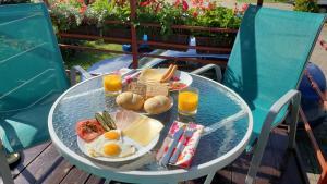 a glass table with food and orange juice on a patio at Willa Wega in Sianozety