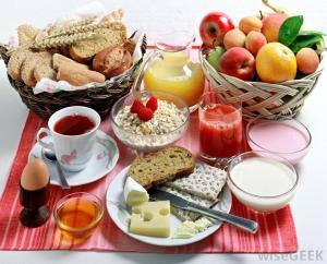 a table with a breakfast of bread and fruit at Petit Porto Cervo in Porto Cervo