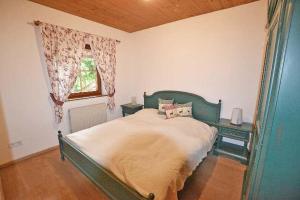 a bedroom with a green bed and a window at Ferienhaus Elisabeth in Ellmau