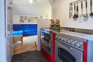 Il comprend une cuisine équipée d'une cuisinière et d'un canapé bleu. dans l'établissement Apartment Katzenkopf, à Leutasch