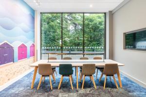 a table and chairs in a room with a large window at Holiday Inn Bournemouth by IHG in Bournemouth