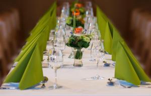 una mesa con servilletas verdes y copas de vino. en Hotel Dorheimer Hof, en Friedberg