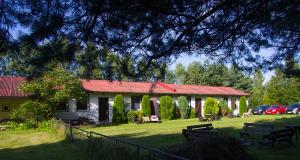a house with a red roof on a yard at Agroturystyka GAGA in Ustka
