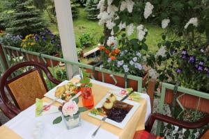 einen Tisch mit einem Teller Essen auf einem Balkon mit Blumen in der Unterkunft Cafe Zur Talsperre in Chemnitz