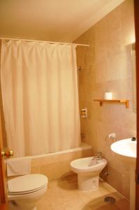 a bathroom with a toilet sink and a shower curtain at Hostal Drago in Pueblo Nuevo de Guadiaro