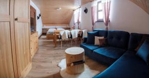 a living room with a blue couch and a table at Chata Marguška - U Fera in Oščadnica