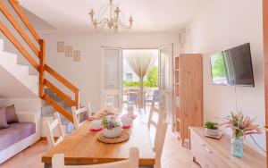 uma sala de jantar e sala de estar com uma mesa de madeira em Villa Orchidea em Torre Santa Sabina