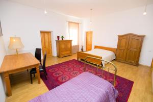 1 dormitorio con cama, escritorio y mesa en Old Town Apartments, en Alytus