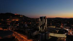 eine Skyline der Stadt in der Nacht mit einem hohen Gebäude in der Unterkunft Crowne Plaza Cappadocia - Nevsehir, an IHG Hotel in Nevşehir