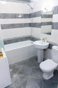 a bathroom with a toilet and a sink and a bath tub at Central Apartment near by Marriott hotel in Novosibirsk