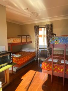 a room with three bunk beds and a tv at Snowgate Motel + Apartments in Berridale