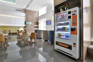 - un grand réfrigérateur dans un restaurant avec des tables et des chaises dans l'établissement Holiday Inn Express Langfang Park View, an IHG Hotel, à Langfang