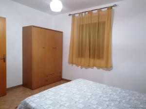 - une chambre avec un lit et une armoire en bois dans l'établissement casa marino, à Montallegro