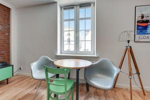 mesa y sillas en una habitación con ventana en Old Town Apartments Apartinfo, en Gdansk