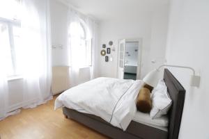 ein weißes Schlafzimmer mit einem Bett, auf dem ein Mann liegt in der Unterkunft Kleine 25 in Solingen