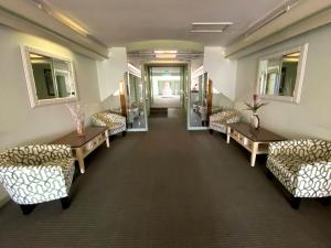 a waiting room with couches and tables and windows at Hollywood Celebrity Hotel in Los Angeles