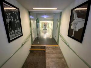a long hallway with two pictures on the walls and a hallway with stairs at Hollywood Celebrity Hotel in Los Angeles
